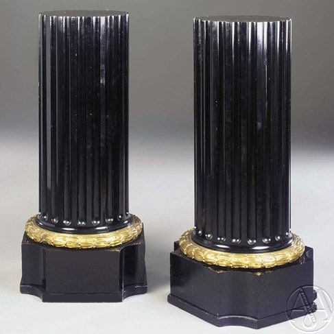 Un par de columnas ebonizadas montadas en bronce dorado