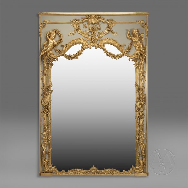 Un miroir Trumeau de style Louis XV finement sculpté, doré et peint.