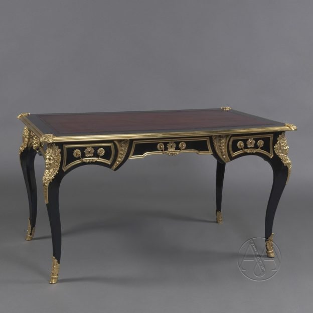 Un beau bureau de style Régence monté en ébène et bronze doré.