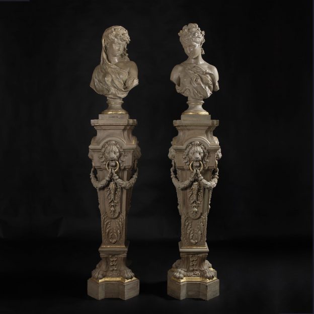 Raro par de bustos y pedestales de hierro fundido pintados en crema y decorados en dorado