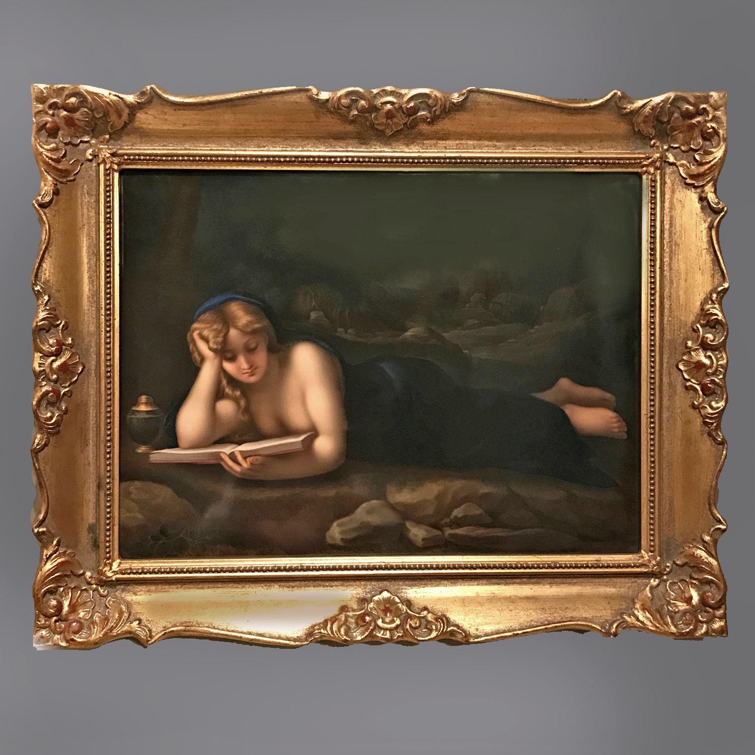 KPM Berlin porcelain plaque of Saint Mary Magdalene reclining and reading a book in a wooded landscape after Correggio, set in a giltwood and gesso frame, circa 1890.