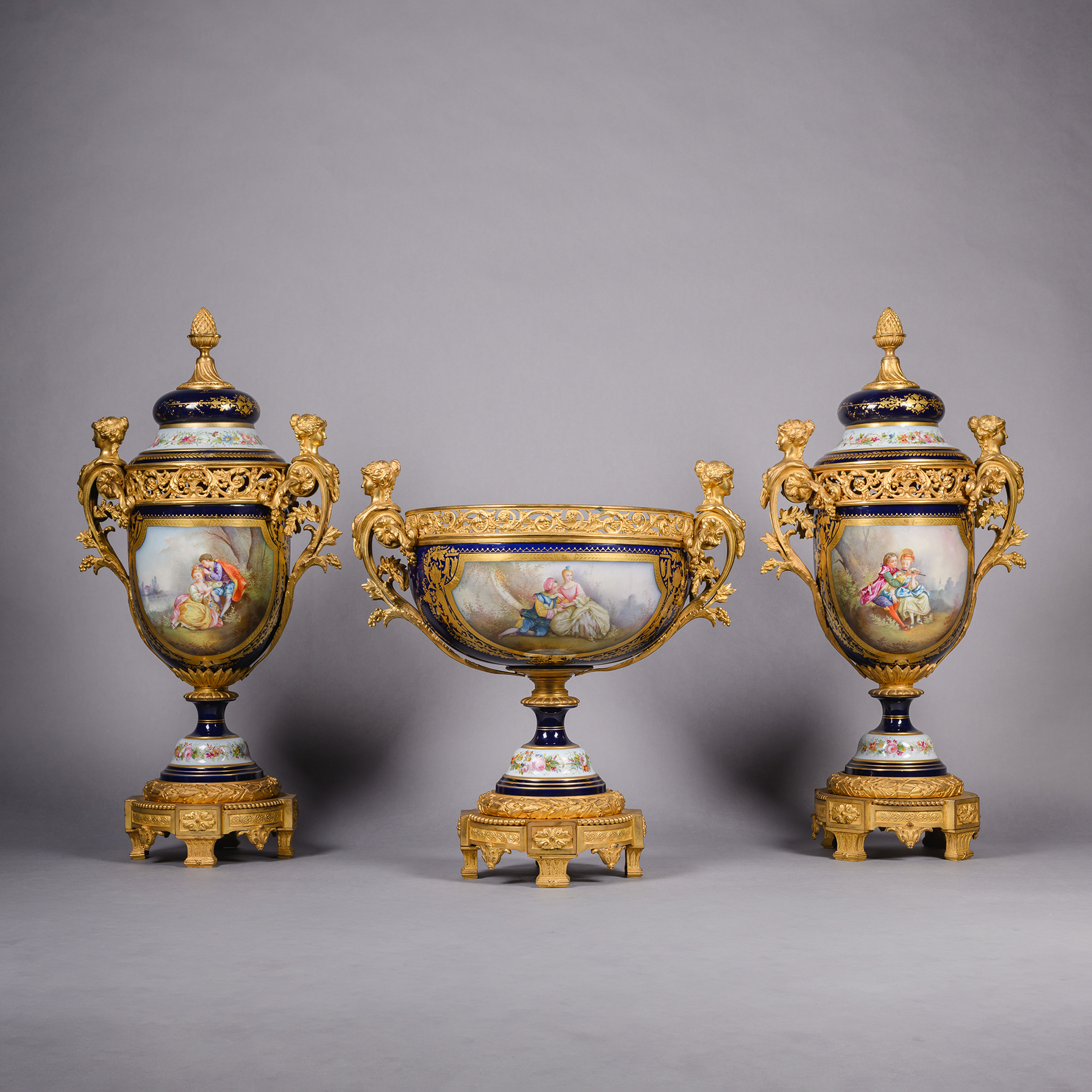 Napoléon III gilt-bronze mounted Sèvres style garniture set with centrepiece and pair of lidded vases, signed Robert, decorated with romantic scenes and floral bouquets, France circa 1870.