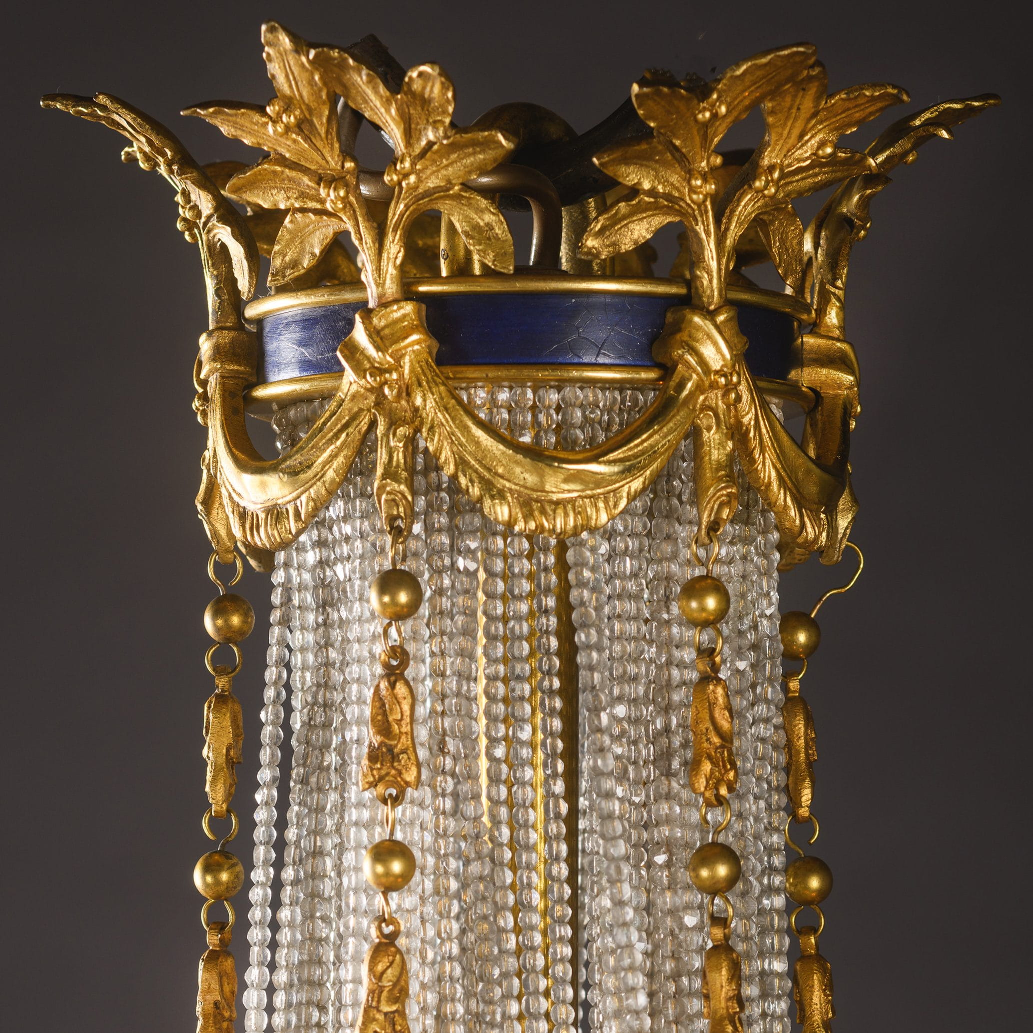 Ornate French chandelier in Louis XVI style, combining cut crystal, gilt-bronze, and blue enamelled details for timeless elegance