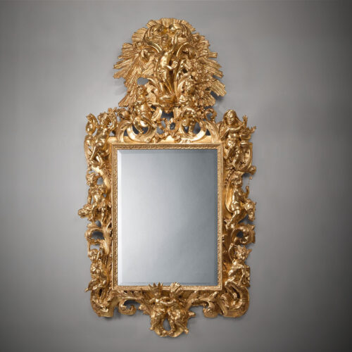 Italian giltwood mirror carved with putti representing the continents and seasons, with scrolling acanthus, C-scrolls, and sunburst cresting, circa 1860.