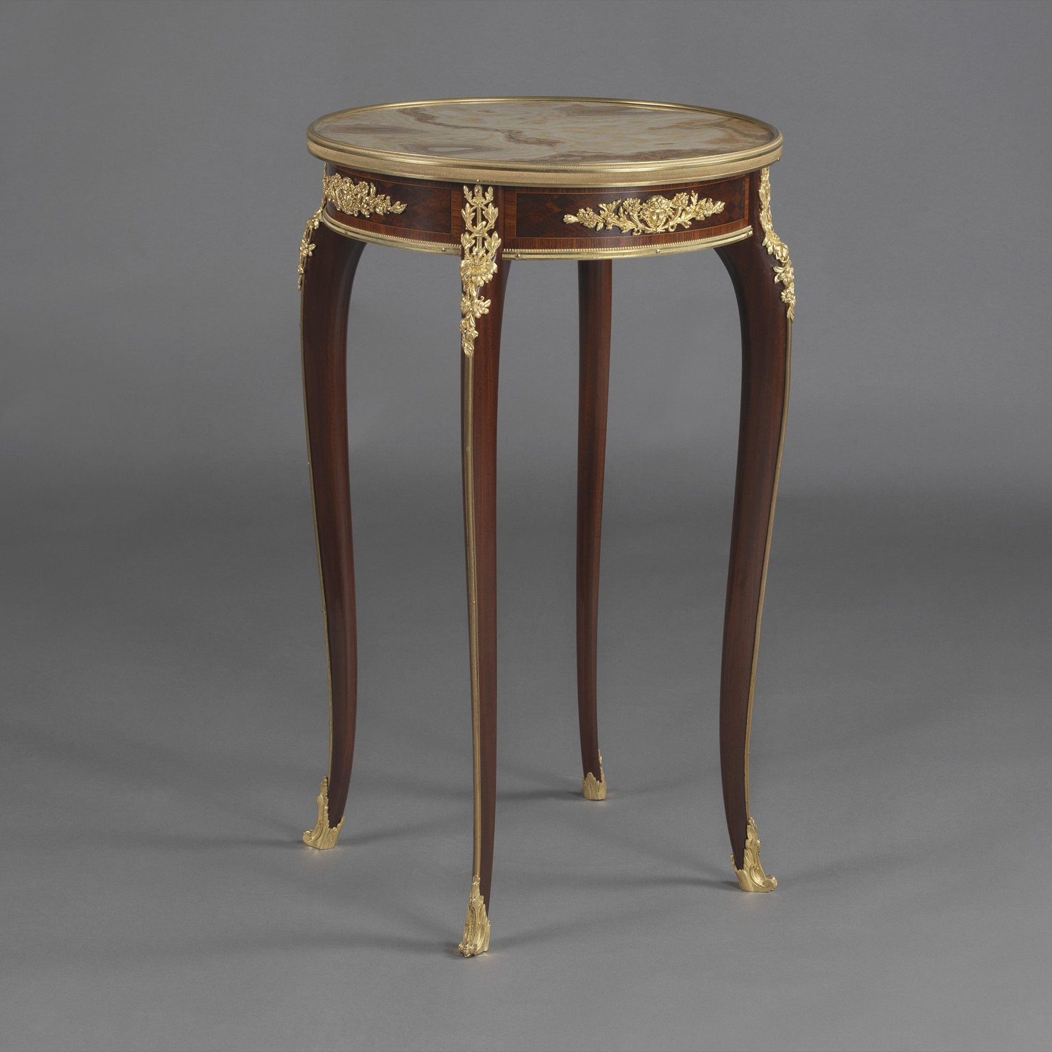 Louis XV style mahogany parquetry gueridon attributed to François Linke with alabastro fiorito marble top, gilt-bronze mounts, cabriole legs, and foliate clasps, circa 1890.