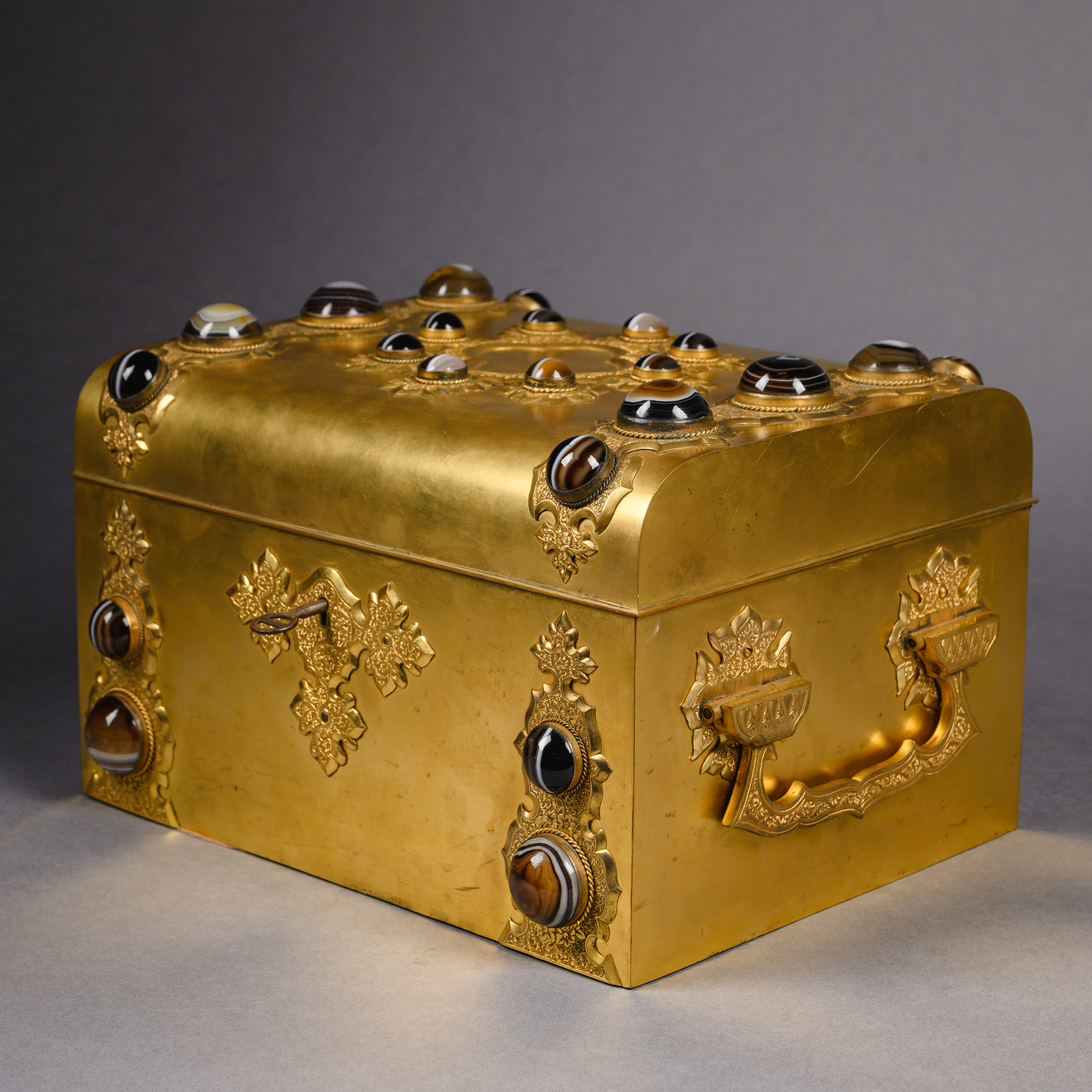 Renaissance Revival gilt-brass dressing table box with agate cabochons and fitted interior including cut-glass containers, mirror, and mother-of-pearl implements, France circa 1870.