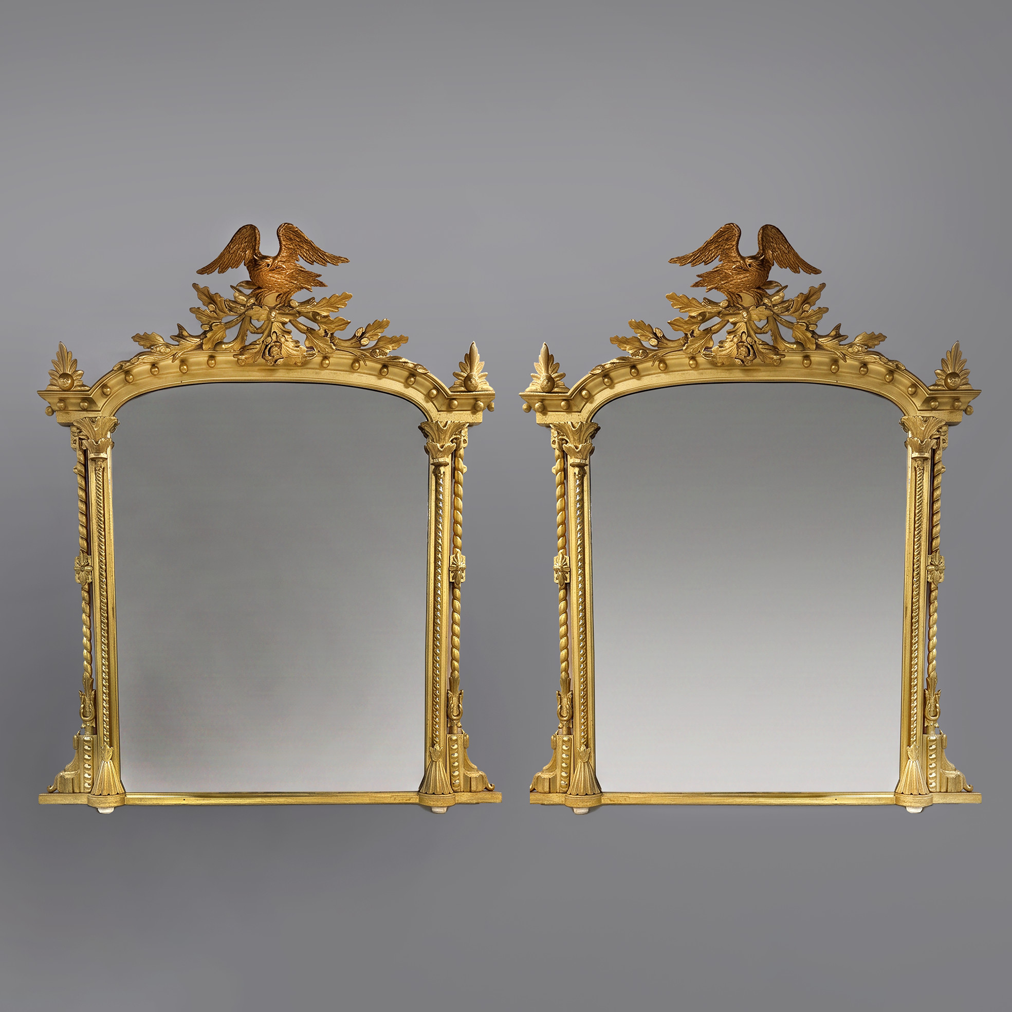 Pair of elaborately carved giltwood overmantel mirrors with eagle cresting