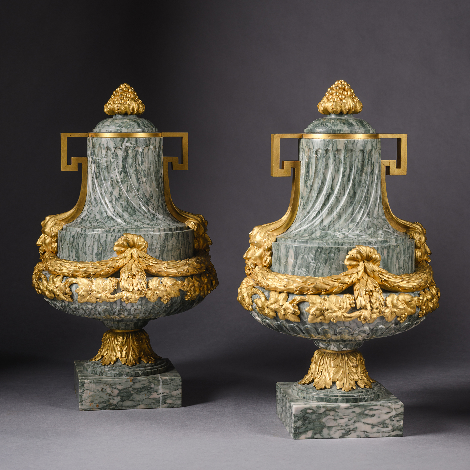 Pair of Louis XVI gilt-bronze mounted green marble baluster vases with laurel and vine leaf mounts, mask terminals, and pomegranate finials, France circa 1870.