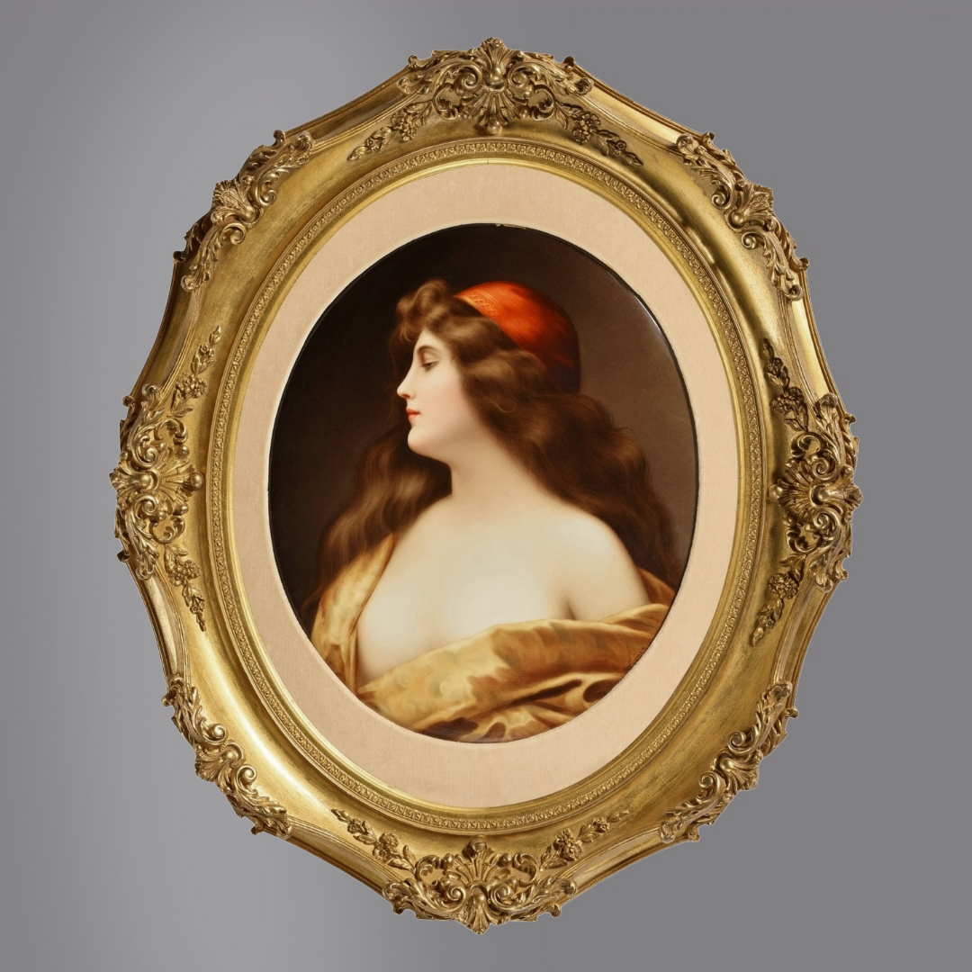 KPM Berlin porcelain plaque titled Una Gitana after Angelo Asti, depicting a young woman in profile wearing a red cap, signed Wagner and marked KPM, in giltwood oval frame, circa 1900.