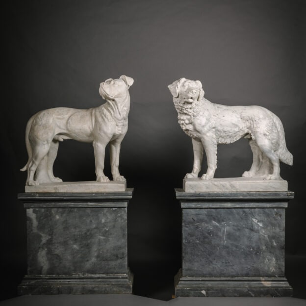 Pareja de perros de mármol de tamaño natural, sobre pedestales, atribuidos a Raffaello Romanelli (1856-1928), Italia, circa 1900.
