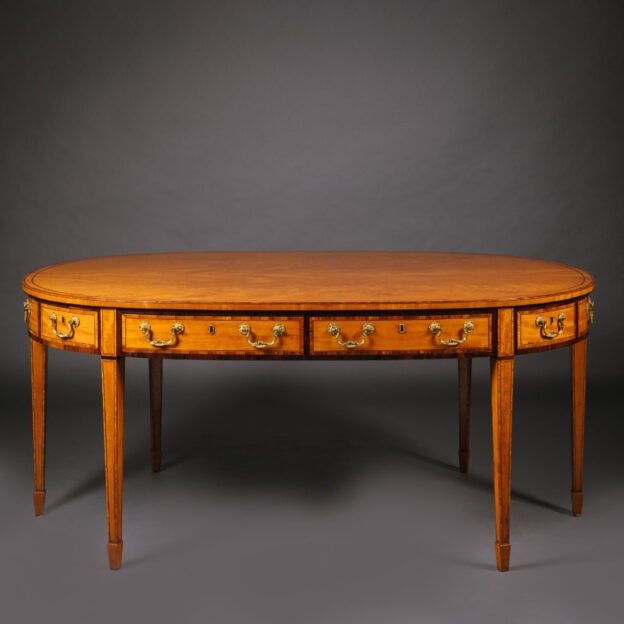 A Late Victorian Satinwood Library Table or Desk, In the Style of Thomas Sheraton. English, Circa 1890.