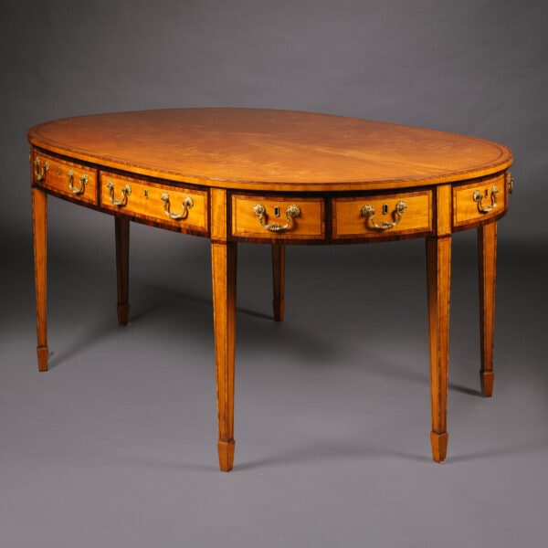 A Late Victorian Satinwood Library Table or Desk, In the Style of Thomas Sheraton. English, Circa 1890.