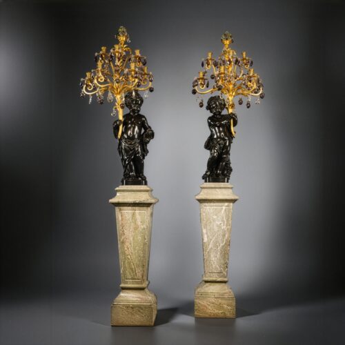 A Pair of Magnificent and Palatial Patinated Bronze Figural Putto Seven-Light Gilt-Bronze, Rock-Crystal and Amethyst Glass Candelabra, On Green Marble Pedestals