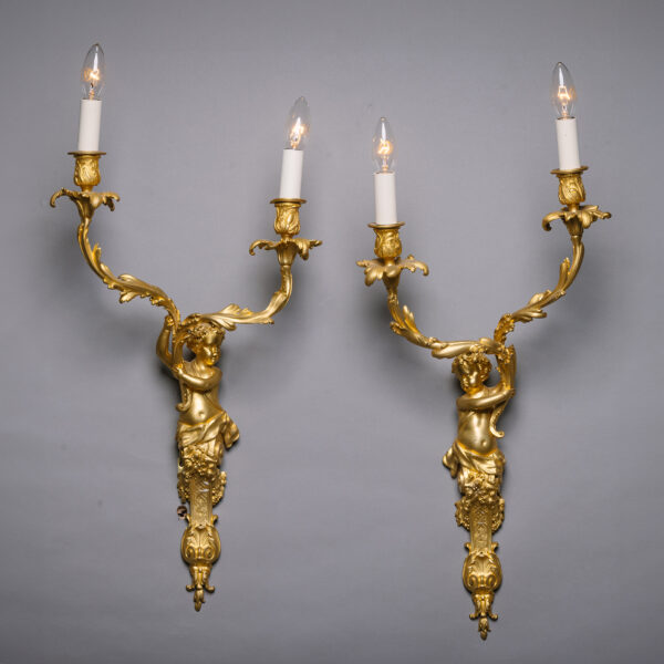 A Pair of Louis XIV Style Gilt-Bronze Twin-Light Wall-Appliques Modelled With Cherubic Herms. In the Manner of André-Charles Boulle