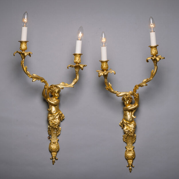 A Pair of Louis XIV Style Gilt-Bronze Twin-Light Wall-Appliques Modelled With Cherubic Herms. In the Manner of André-Charles Boulle