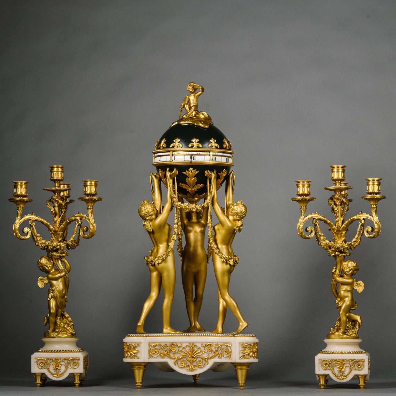 A Louis XVI Style Gilt and Patinated Bronze and Marble Clock Garniture ...