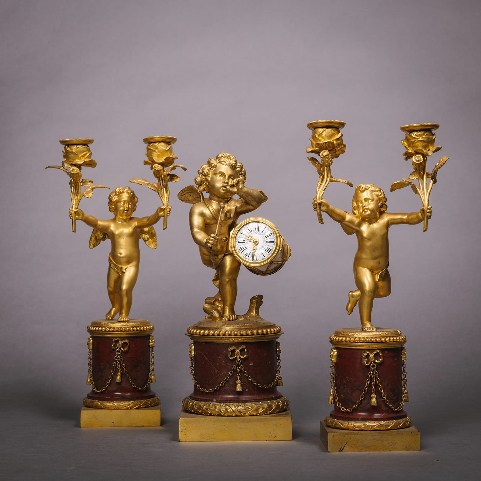 A Fine Rouge Marble Figural Timepiece and Garniture