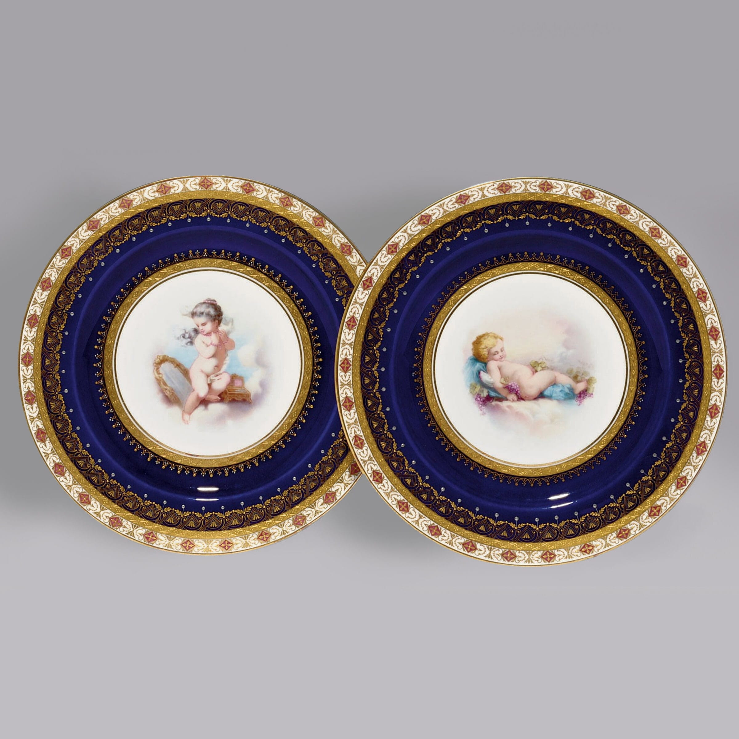 A Very Decorative Pair of Porcelain Plates Depicting Putto at Play