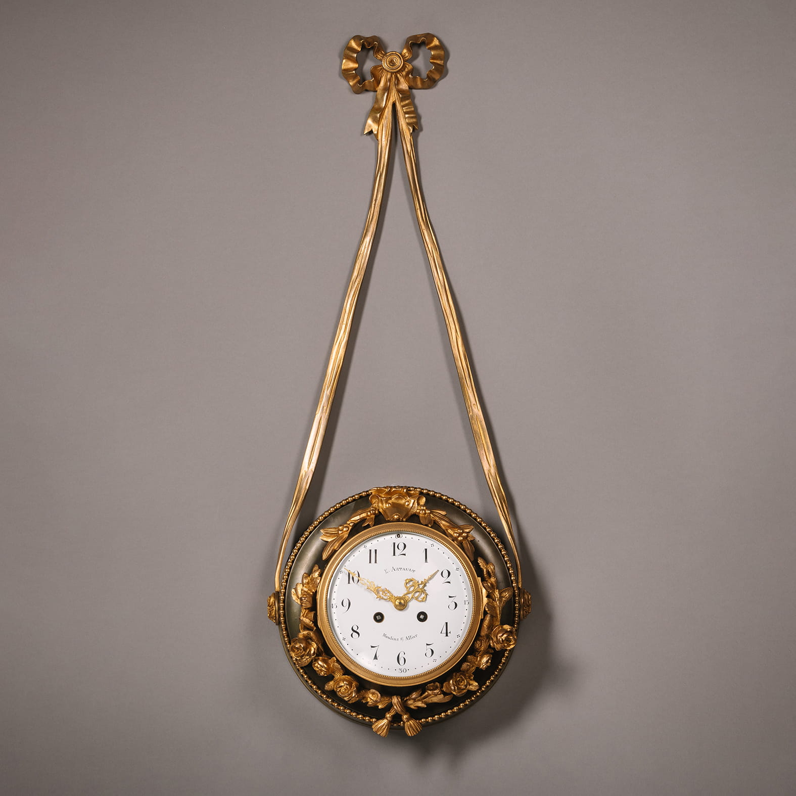 A Patinated and Gilt-Bronze Hanging Clock, with an enamelled dial and Arabic Numerals