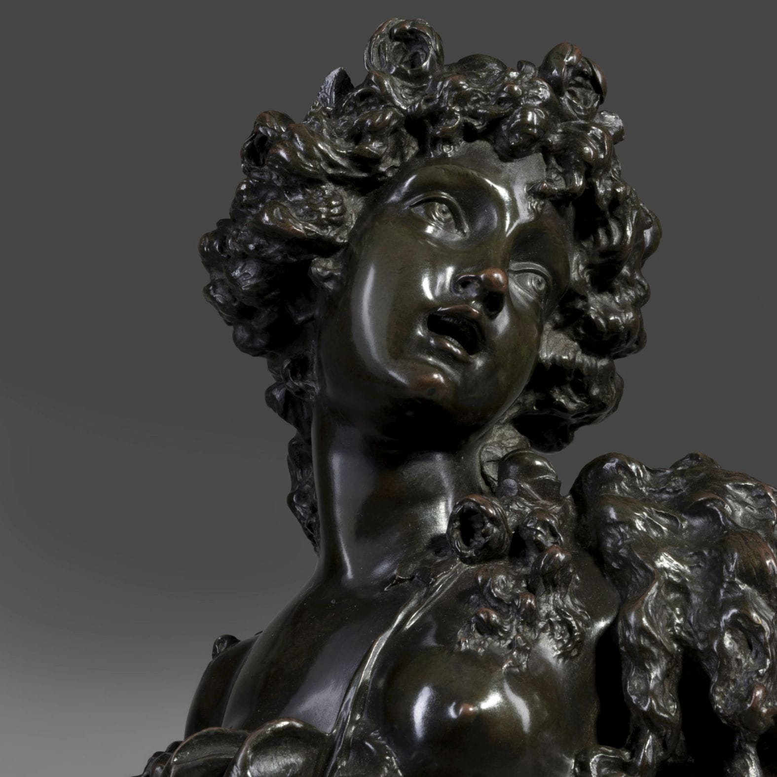 Pair of patinated bronze busts of Bacchantes, one with roses symbolizing Summer and the other with oak leaves for Autumn, after Marin, on gilt-bronze socles and granite plinths, French circa 1890.