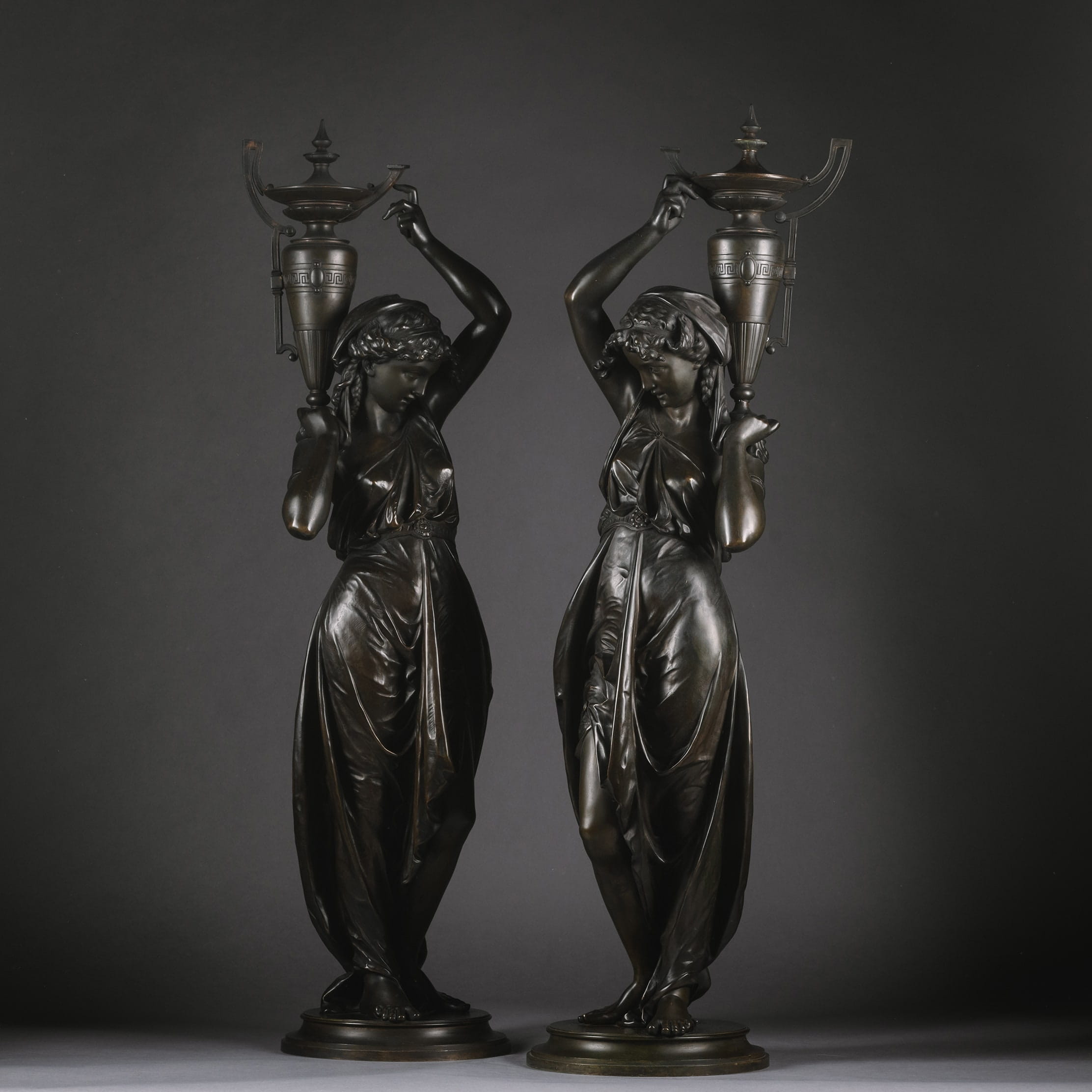 A Pair Of Napoleon III Patinated-Bronze Figures, Modelled As Classically Robed Maidens Bearing Urns