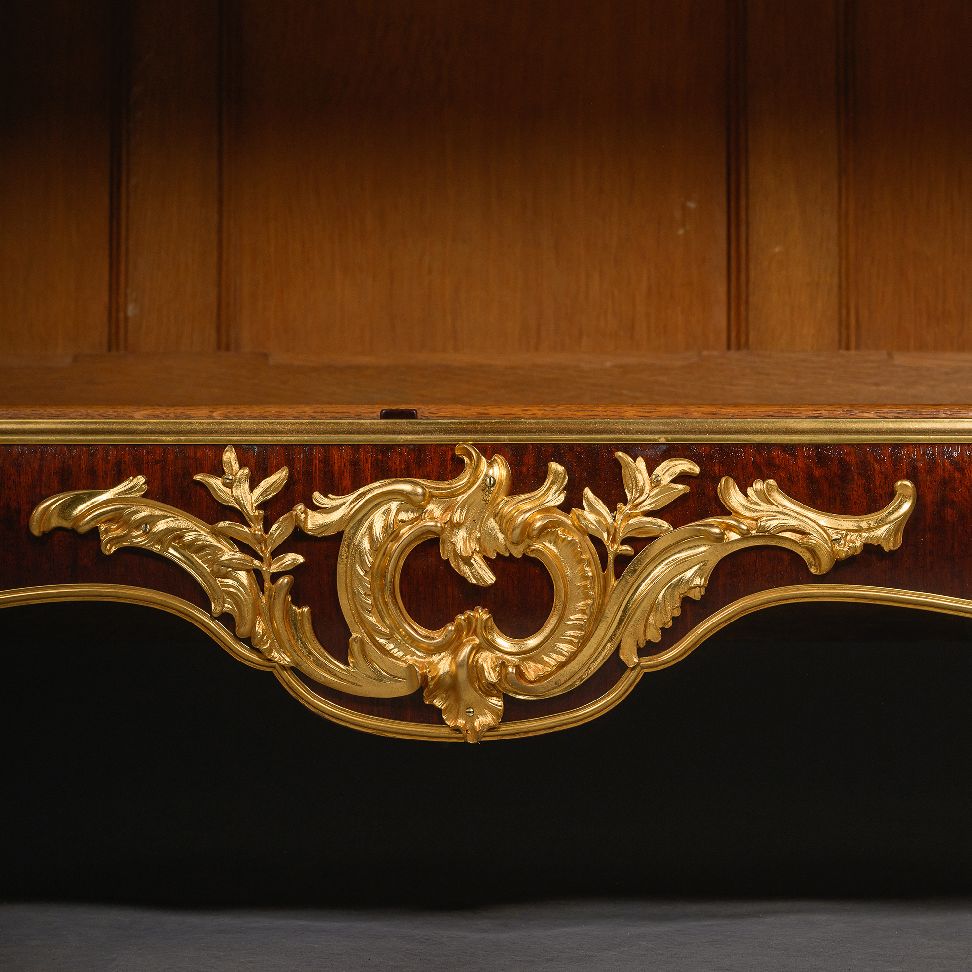ocaille gilt-bronze mount and serpentine apron on a Régence revival mahogany cabinet.