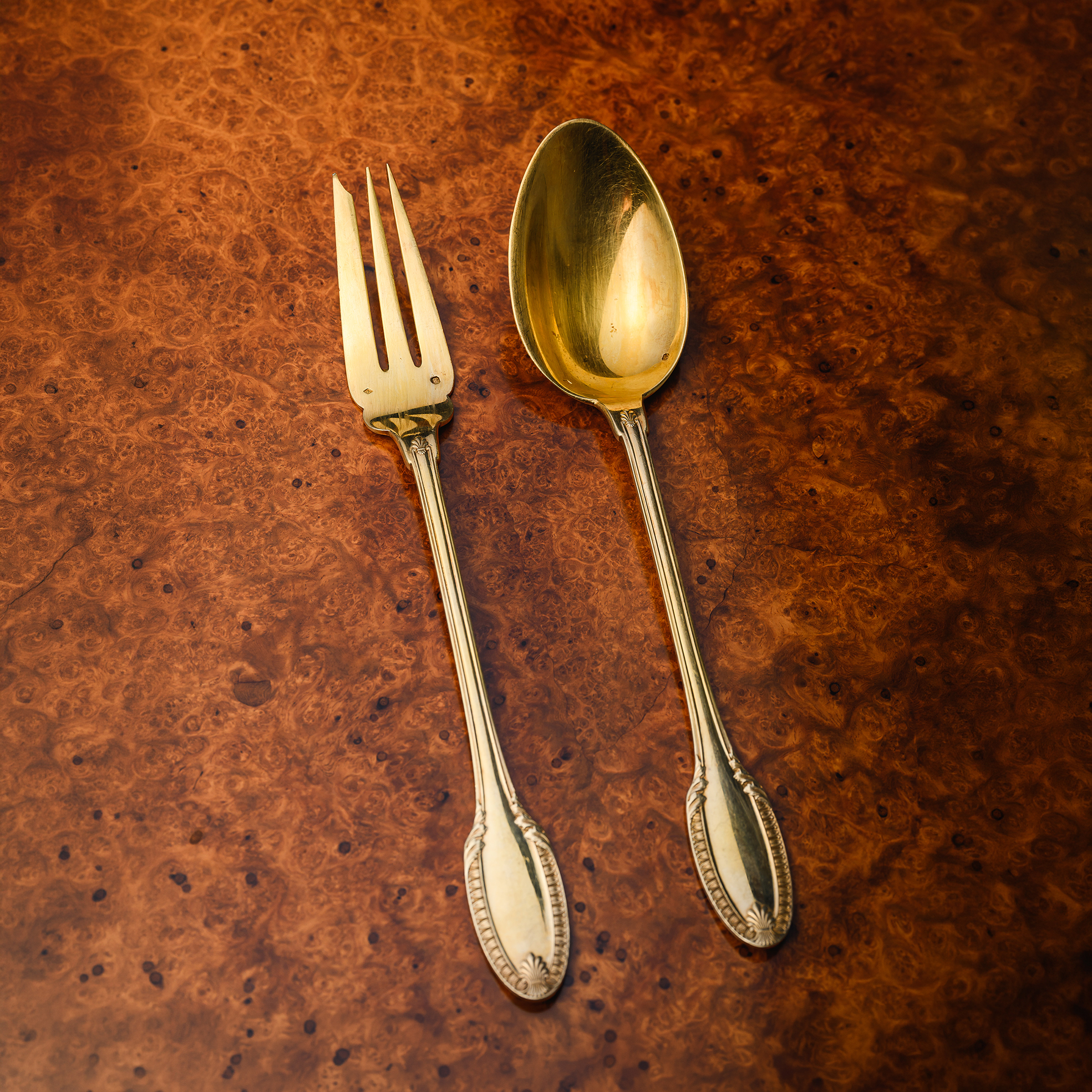 Puiforcat silver-gilt serving spoon and fork in the Percier pattern, larger scale pieces with flowing neoclassical detailing, designed for formal table service