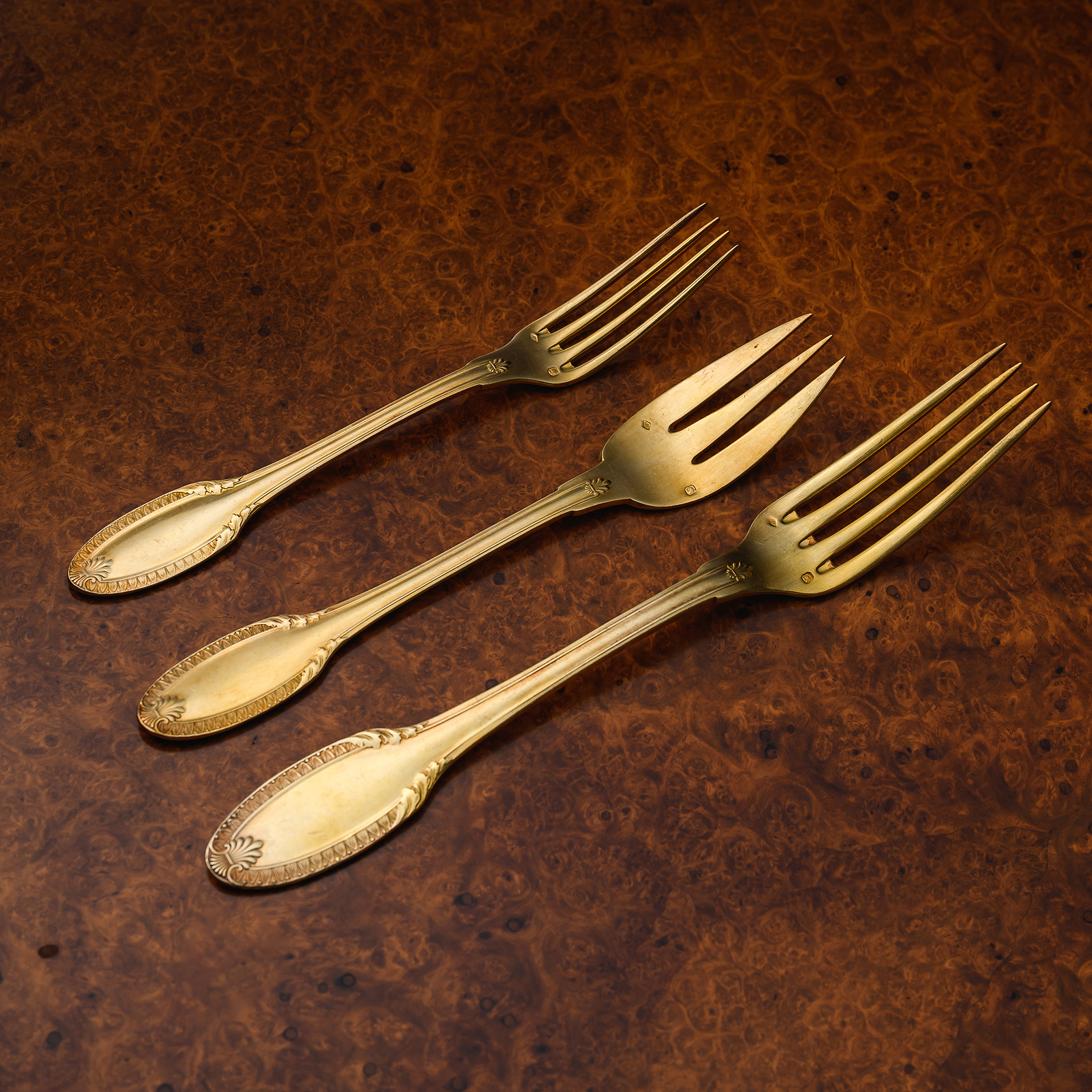 Set of Puiforcat Percier pattern silver-gilt table forks, each with finely chased neoclassical ornament and elegant proportions