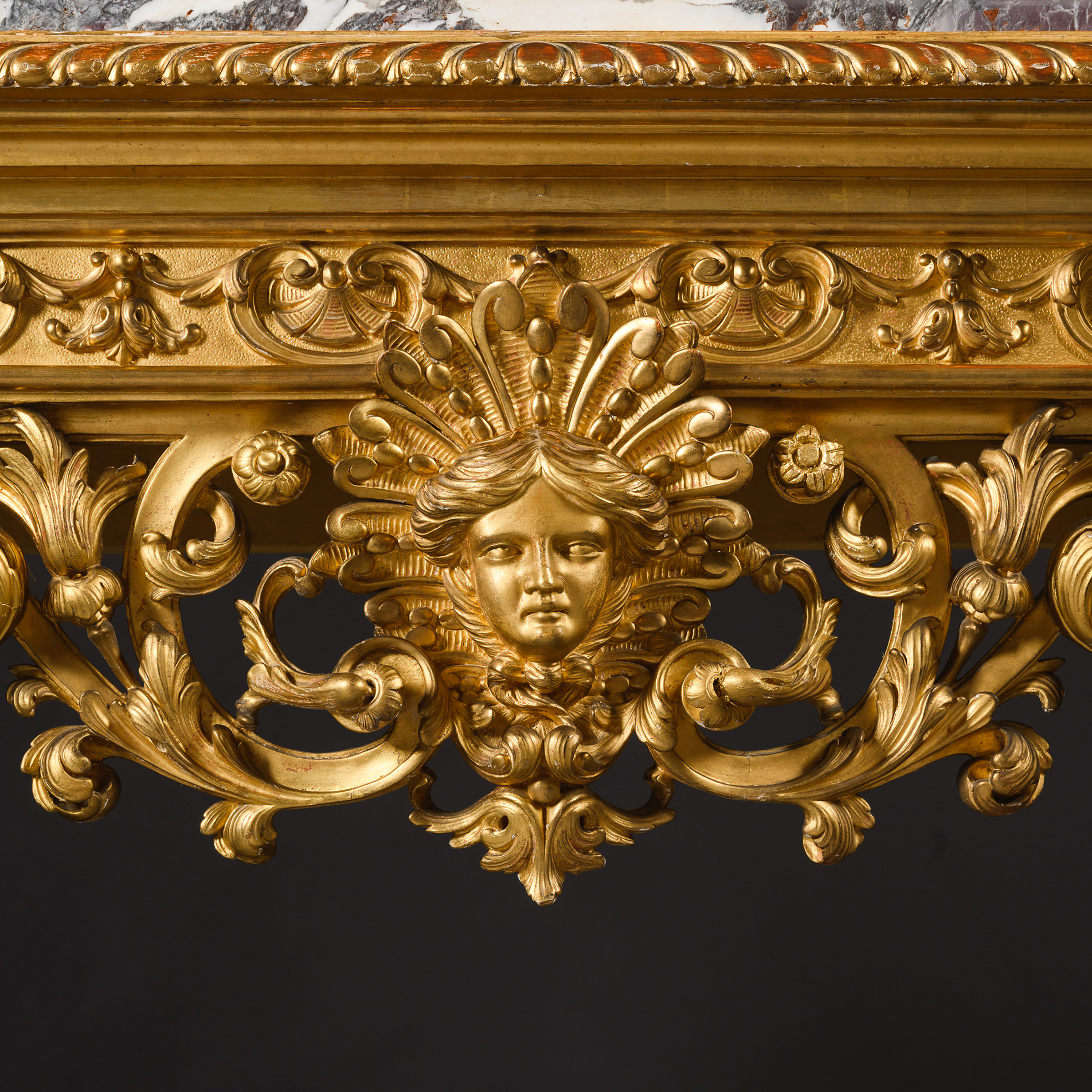 Carved Apollo mask to the frieze of a nineteenth-century Louis XIV style giltwood console table.