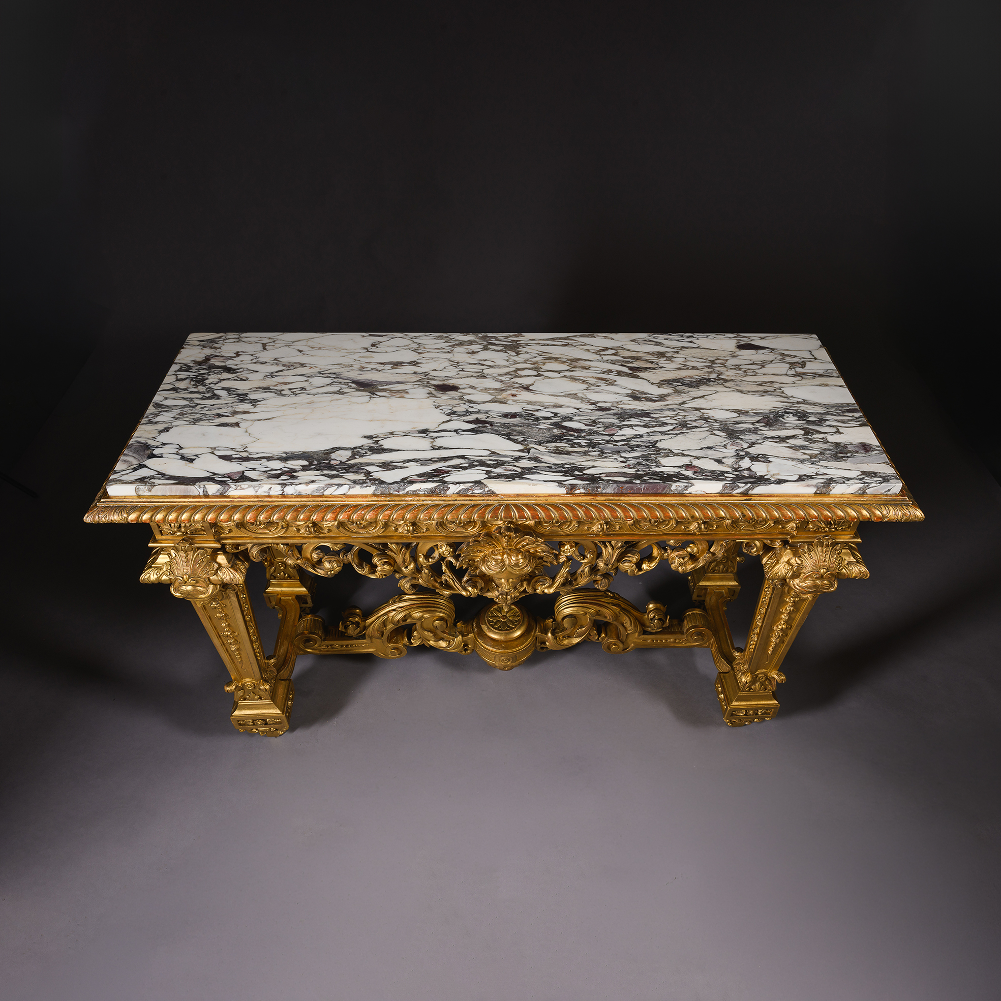 Carved lambrequins and scrolling giltwood ornament on the console table frieze.