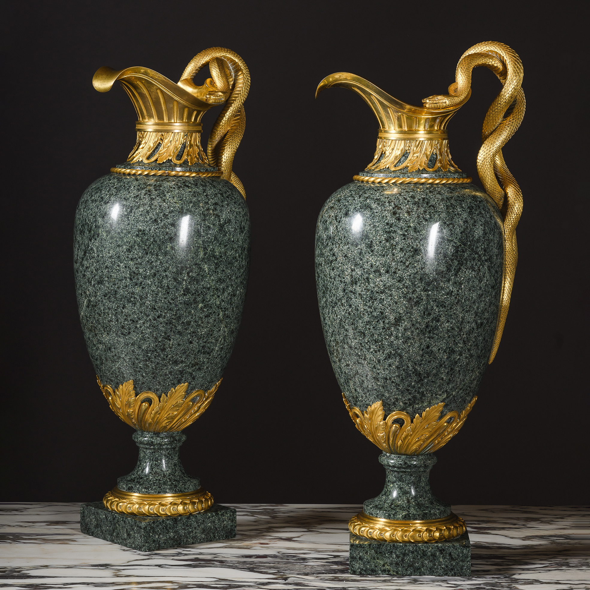 Pair of Louis XVI style green granite ewers by Henry Dasson displayed together with matching gilt-bronze mounts.