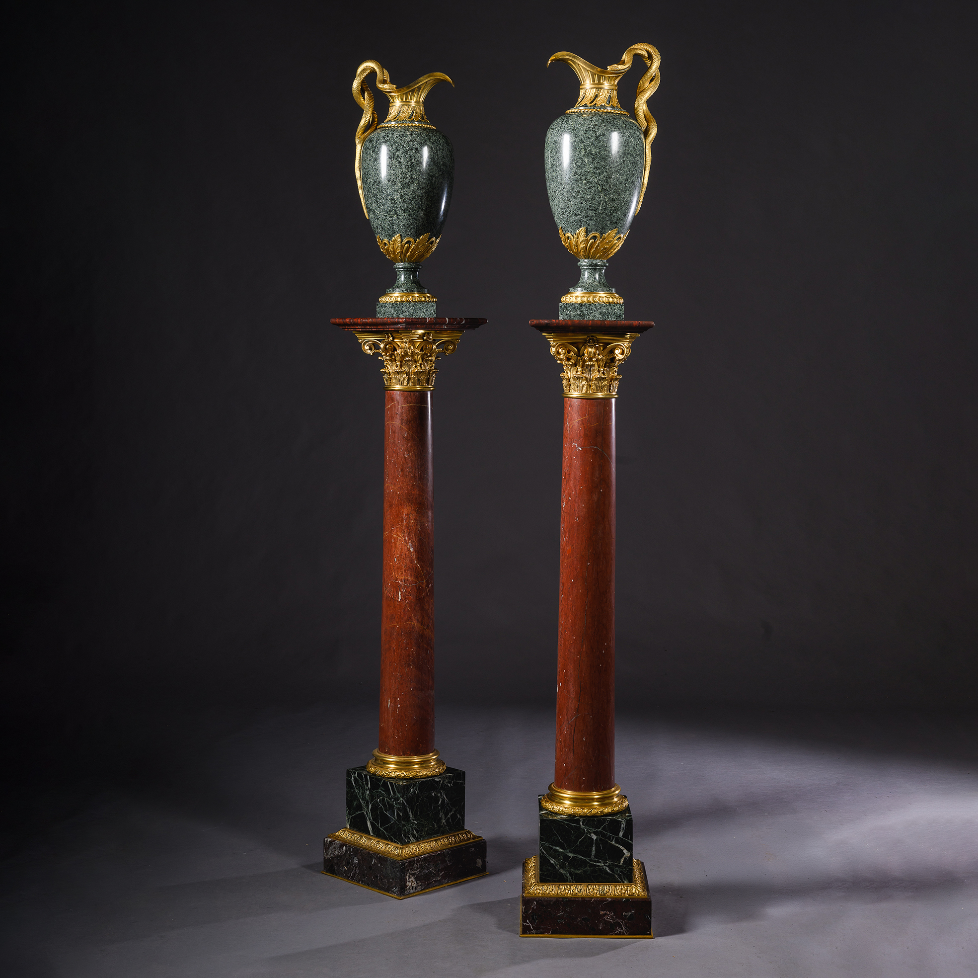 Pair of Louis XVI style gilt-bronze mounted green granite ewers by Henry Dasson shown on a fine pair of marble columns