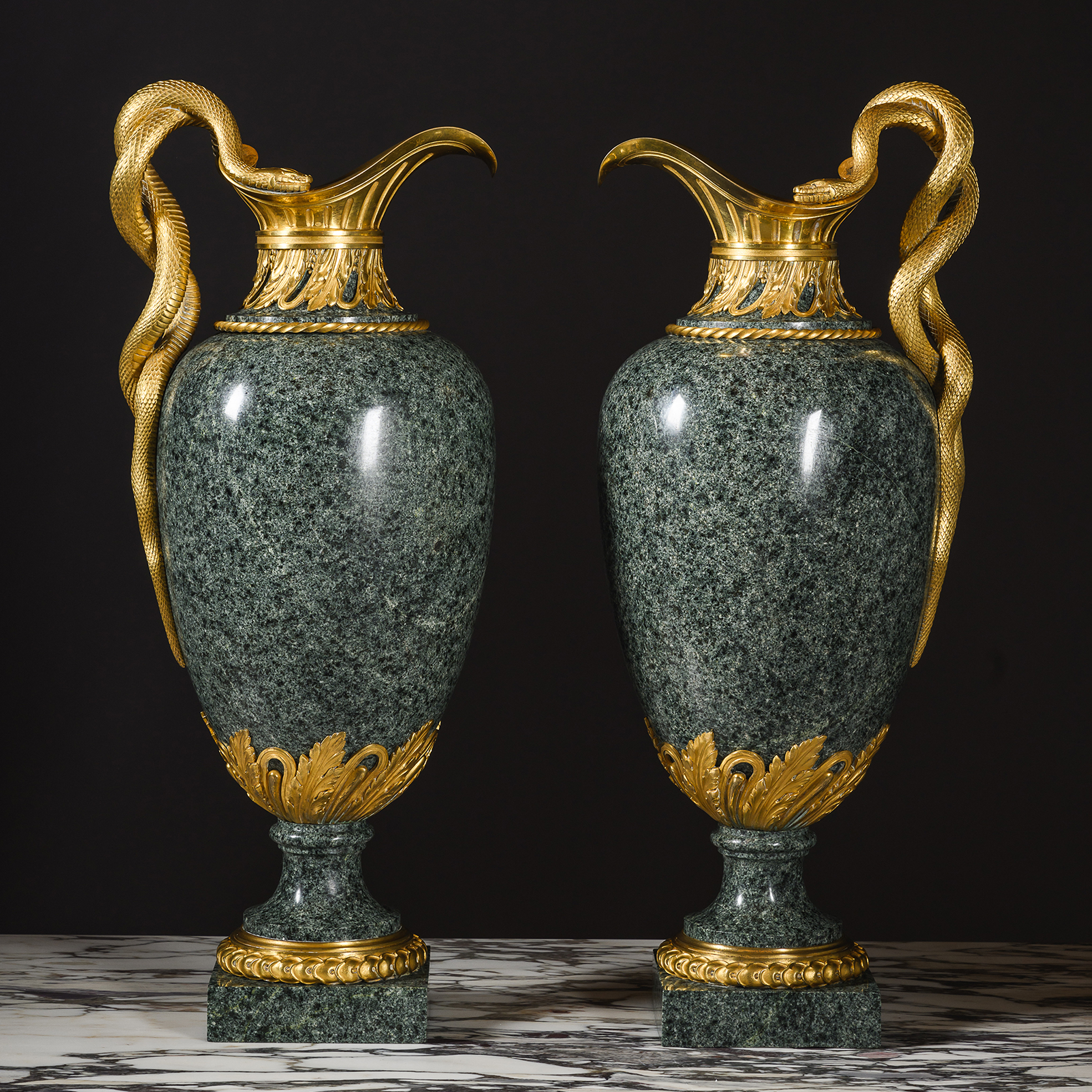 Pair of Louis XVI style gilt-bronze mounted green granite ewers by Henry Dasson, Paris, circa 1880, with entwined serpent handles.